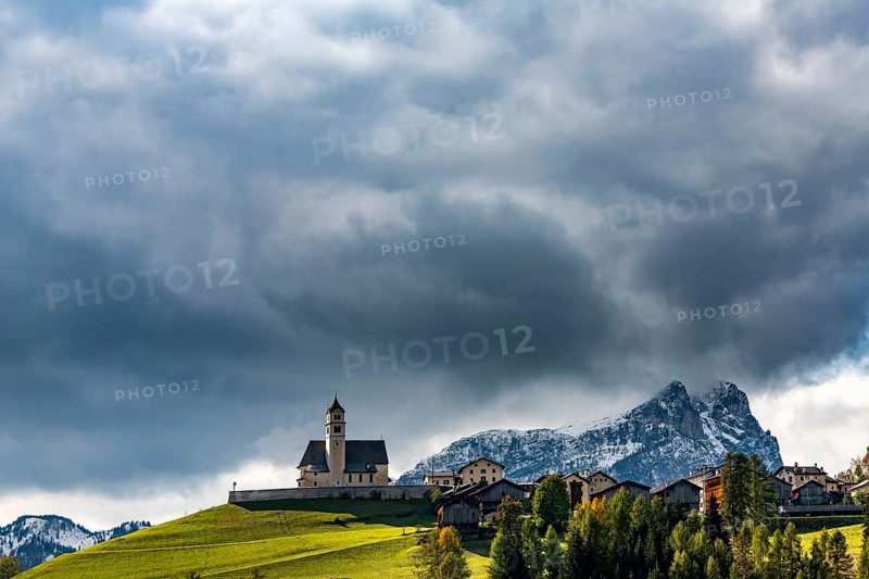 Church of Colle Santa Lucia with snowy mountain peak in the background