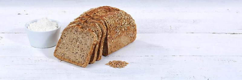 Bread multigrain bread wholemeal bread grain bread cut slice banner text free space on wooden plate