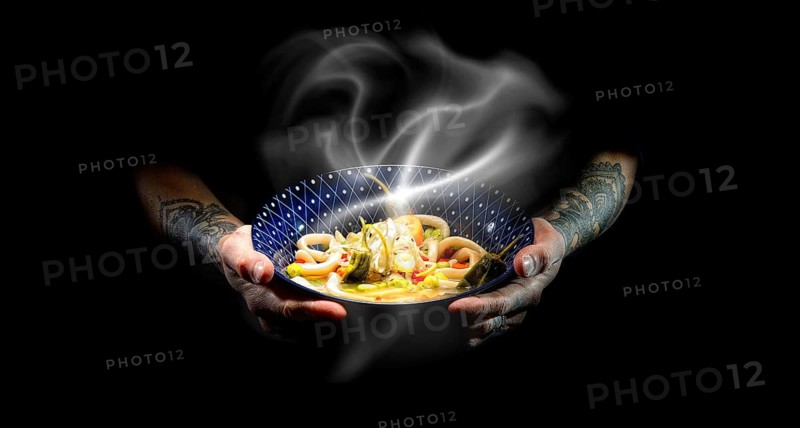Tattooed hands hold plate with udon bowl