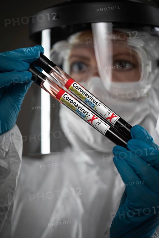Female Lab Worker Holds Test Tubes of Blood Labeled Coronavirus COVID-19 Disease