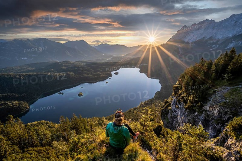Hiker looking at Eibsee lake at sunrise