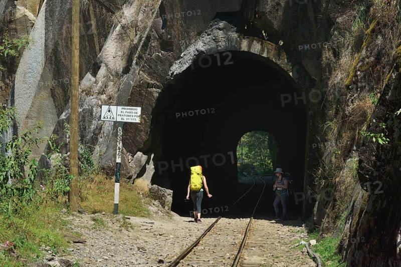 Tourists with backpack in the tunnel of the railway to Cusco
