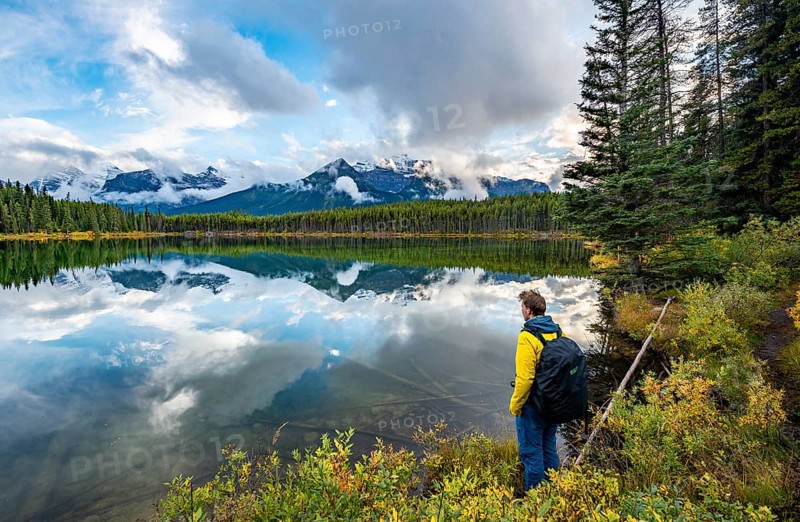 Hiker at the lakeside looking at mountains