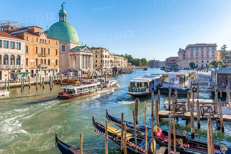 Gondolas and boats on the Grand Canal with church San Simeone Piccolo at the Ponte degli Scalzi