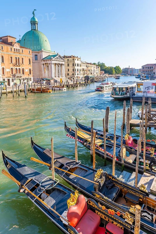 Gondolas and boats on the Grand Canal with church San Simeone Piccolo at the Ponte degli Scalzi