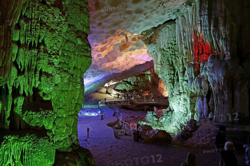 Visitors in large limestone karst cave with stalactite and stalagmite formations