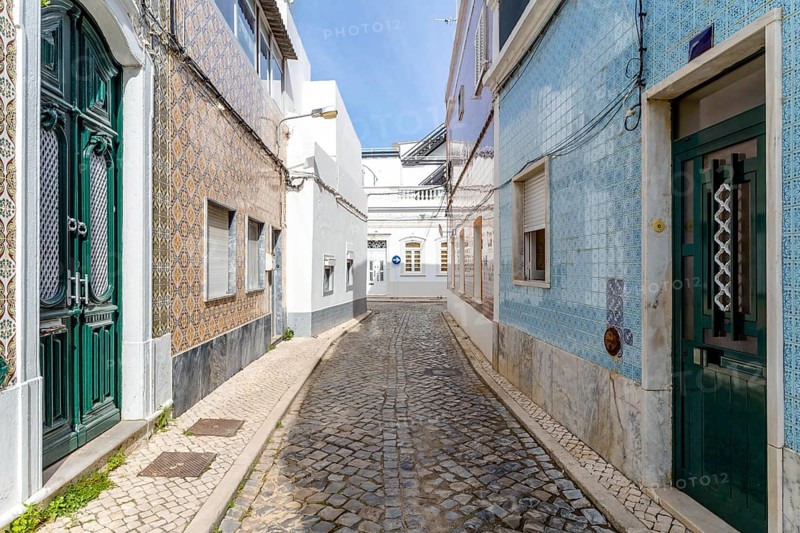 Narrow street with traditional fishermen's houses in Olhao