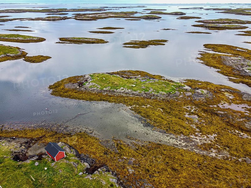 Aerial of a red boat shed on the rugged coastline of the Unesco world heritage site