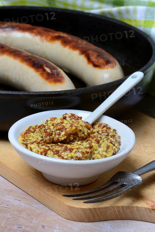 Bowl of Dijon mustard and sausages