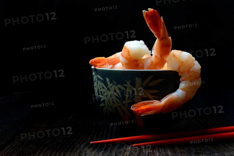 Cooked prawns in shell with chopsticks
