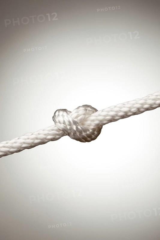 Nylon rope knot on a spot lit background