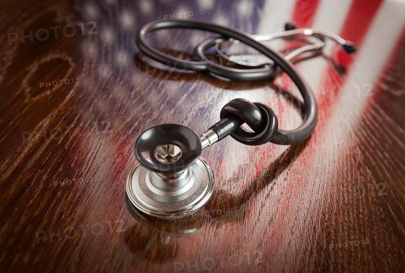 Knotted stethoscope with american flag reflection on wooden table