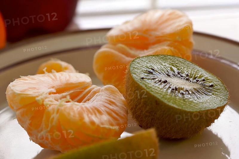 Kiwi and clementine tangerines on a plate in early morning light