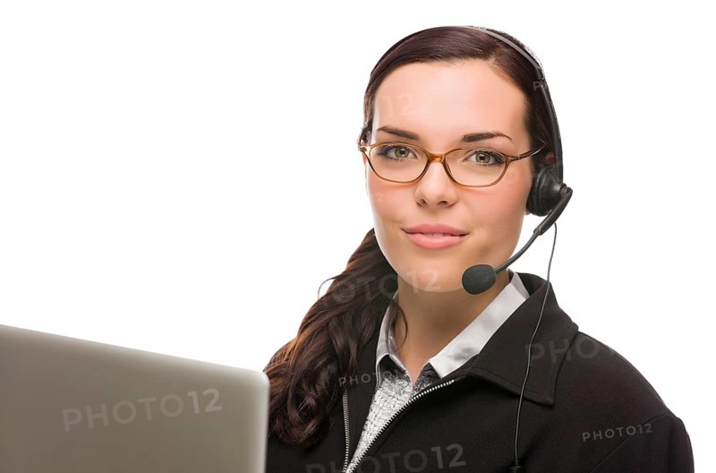 Helpful mixed-race receptionist in front of computer wearing phone head-set isolated on white background