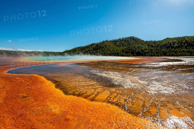 Steaming hot spring with colored mineral deposits