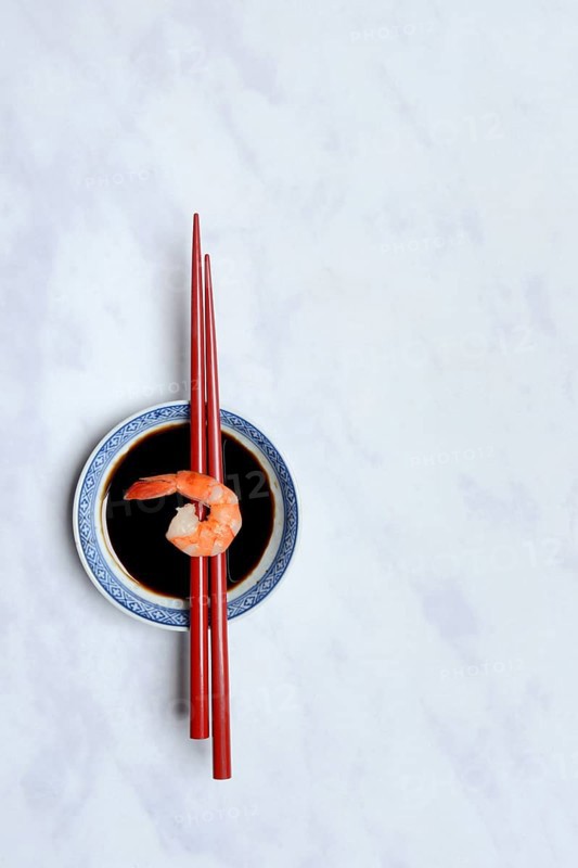 Cooked shrimp on chopsticks and shell with soy sauce