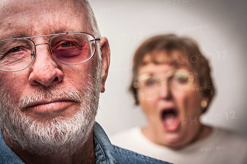 Battered and scared man with screaming angry woman behind