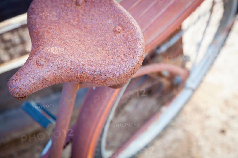 Abstract of old rusty antique bicycle seat in a rustic outdoor setting