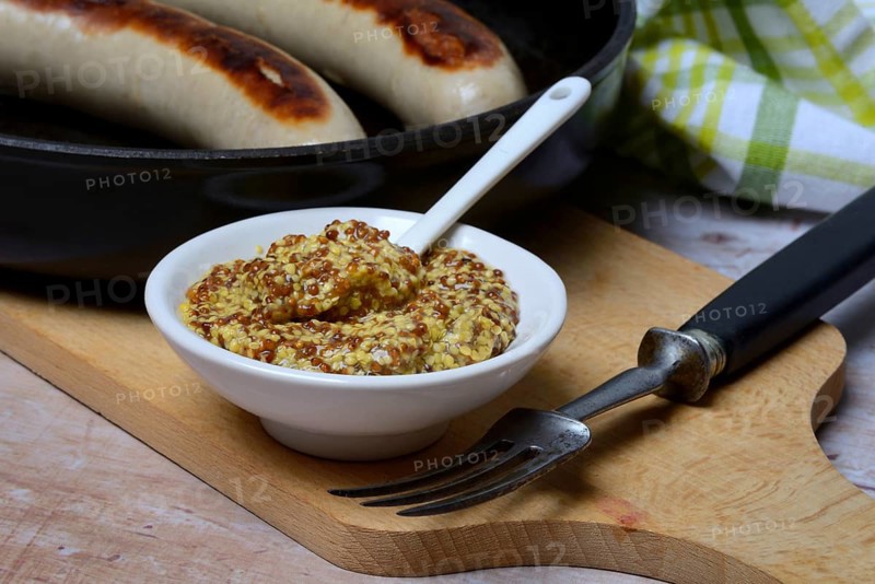 Bowl of Dijon mustard and sausages