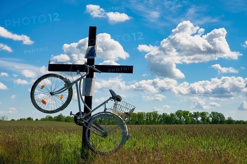 Cross with bicycle at country road near Trebbin