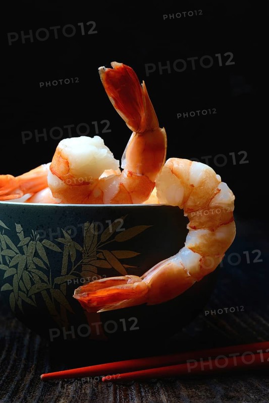 Cooked prawns in shell with chopsticks