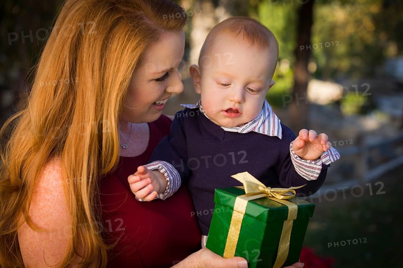 Beautiful young mother and smiling baby with wrapped christmas gift