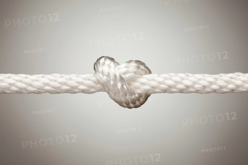 Nylon rope knot on a spot lit background