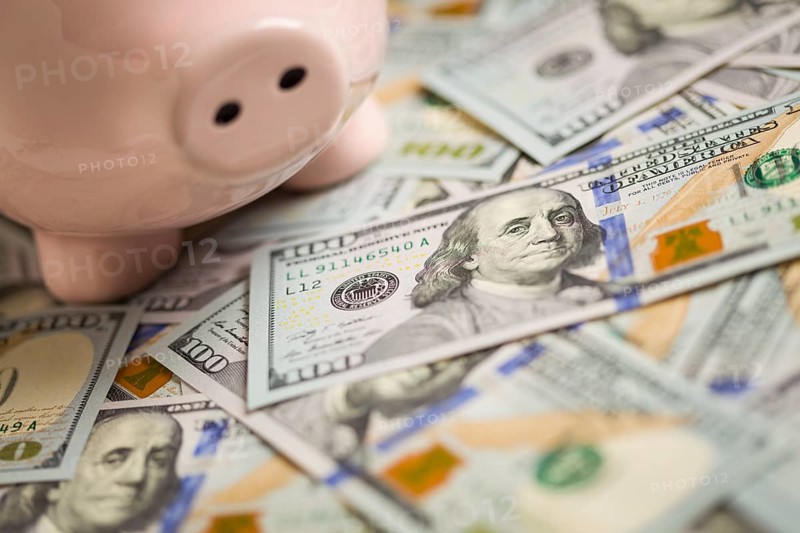 Piggy bank on stacks of newly designed one hundred dollar bills