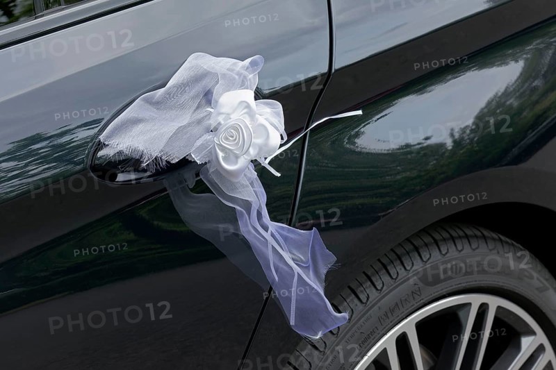 White bow on the door handle of a black car