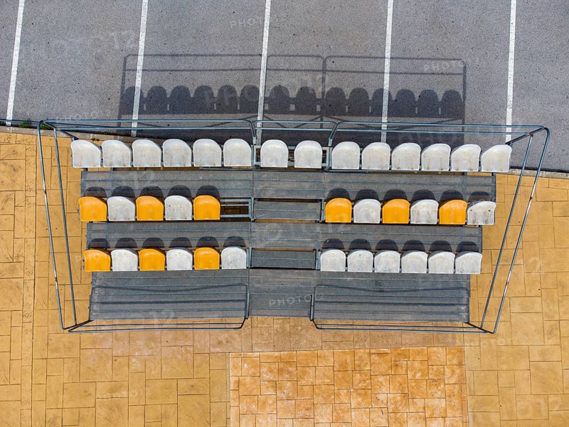Aerial view of small stands next to parking lot with seats for spectators at a fooball pitch in Altea La Vella