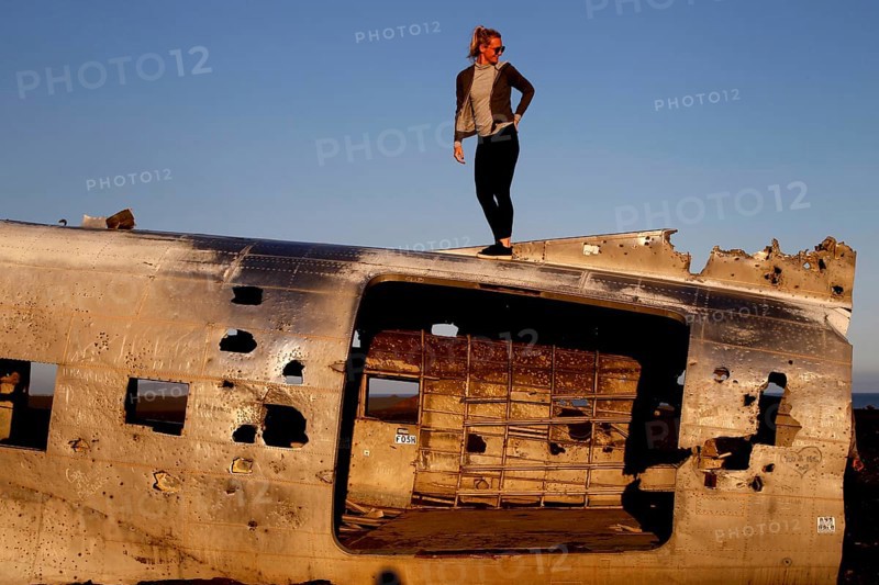 Woman climbing on plane wreckage