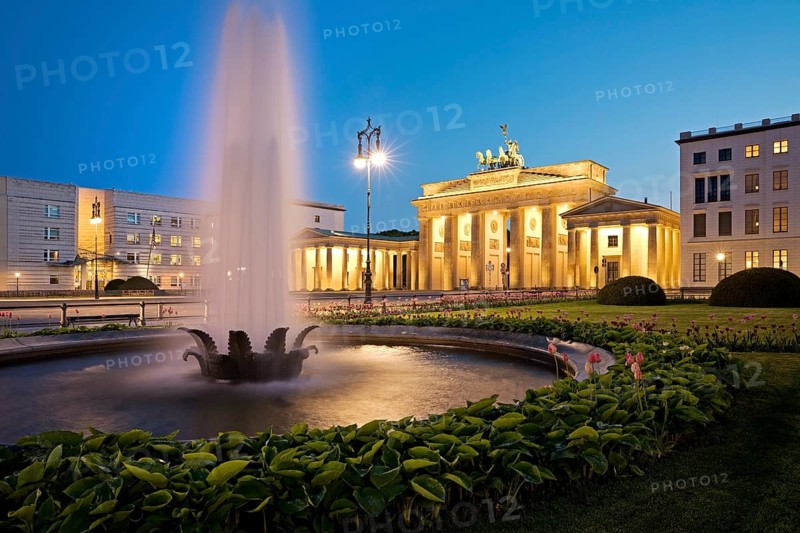Illuminated Brandenburg Gate with fountain and Pariser Platz in the evening