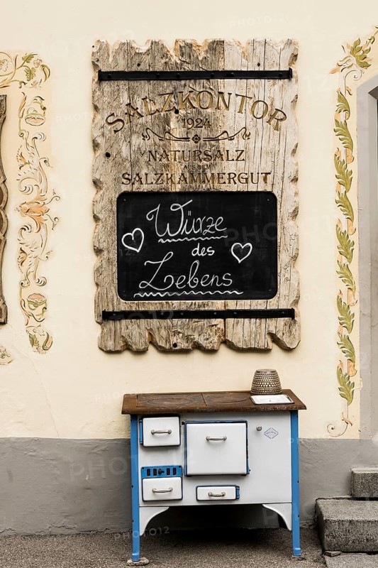 Advertising board and old stove in front of the soap manufactory Salzkontor in the UNESCO World Heritage Hallstatt at Lake Hallstatt