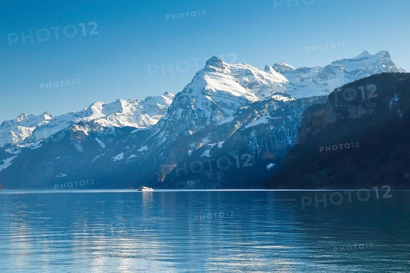 View from Brunnen on a boat on the Lake of Uri in front of the mountain scenery of the Alps of Uri