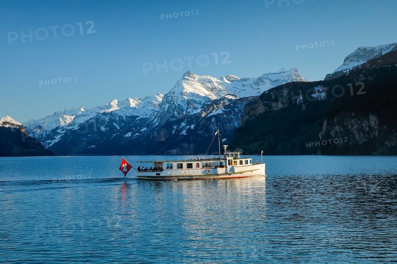View from Brunnen on a boat on the Lake of Uri in front of the mountain scenery of the Alps of Uri