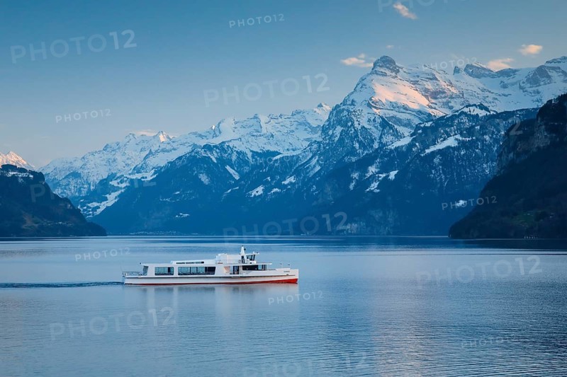 View from Brunnen on a boat on the Lake of Uri in front of the mountain scenery of the Alps of Uri