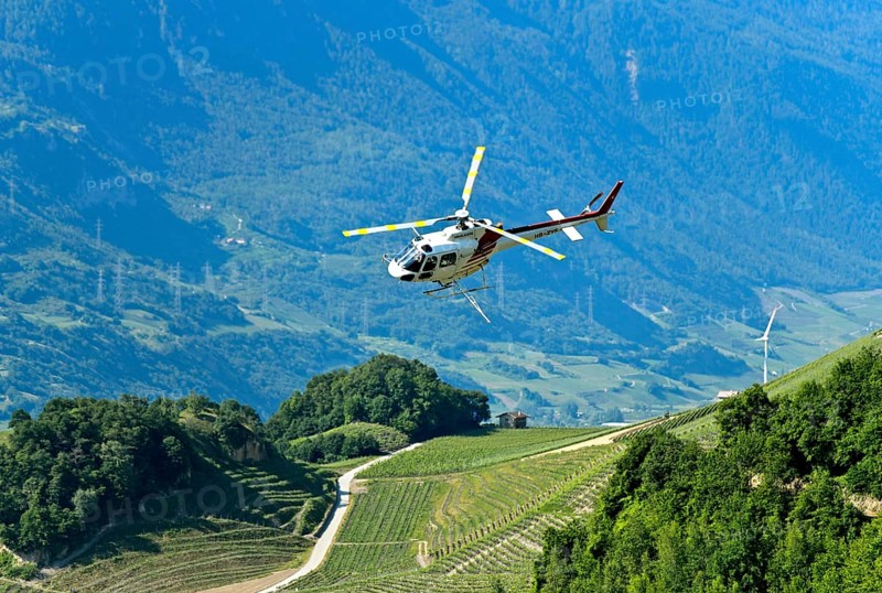 Helicopter Eurocopter AS350 B2 Ecureuil of Air-Glaciers SA sprays pesticides on vineyards in the wine-growing area of Leytron