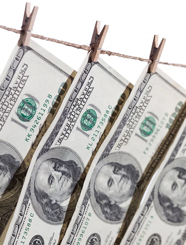 Hundred dollar bills hanging from clothesline on a white background