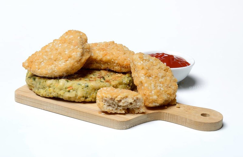 Meat substitute on wooden board and tray with ketchup