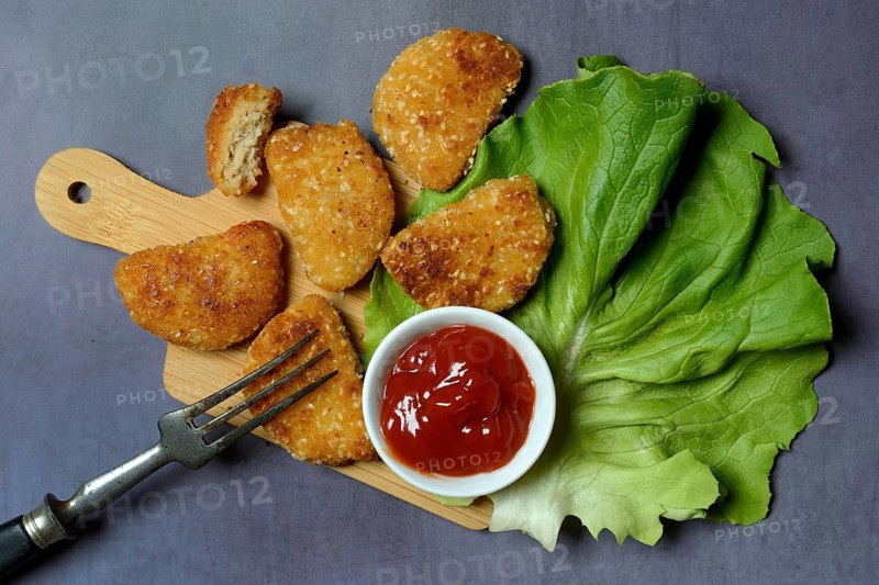 Meat substitute on wooden board and tray with ketchup