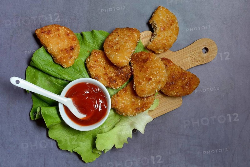 Meat substitute on wooden board and tray with ketchup