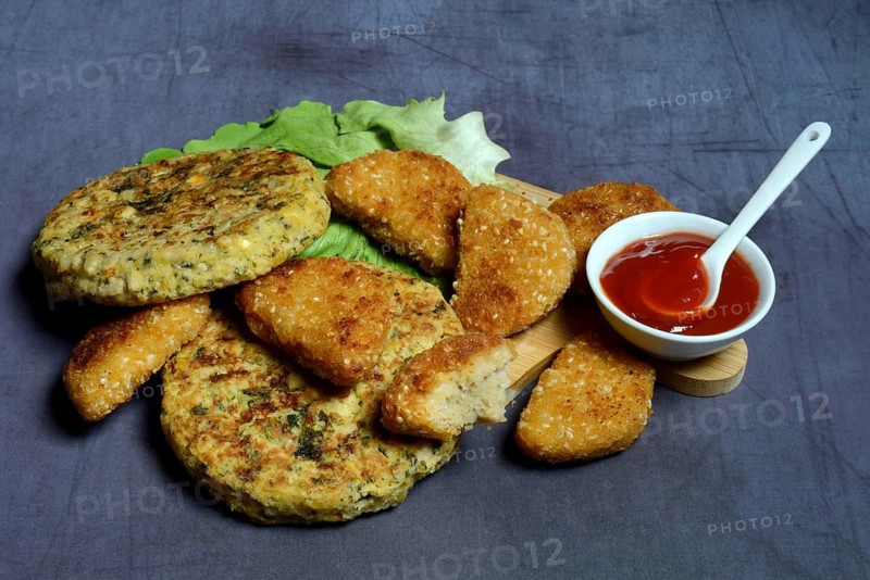 Meat substitute on wooden board and tray with ketchupl