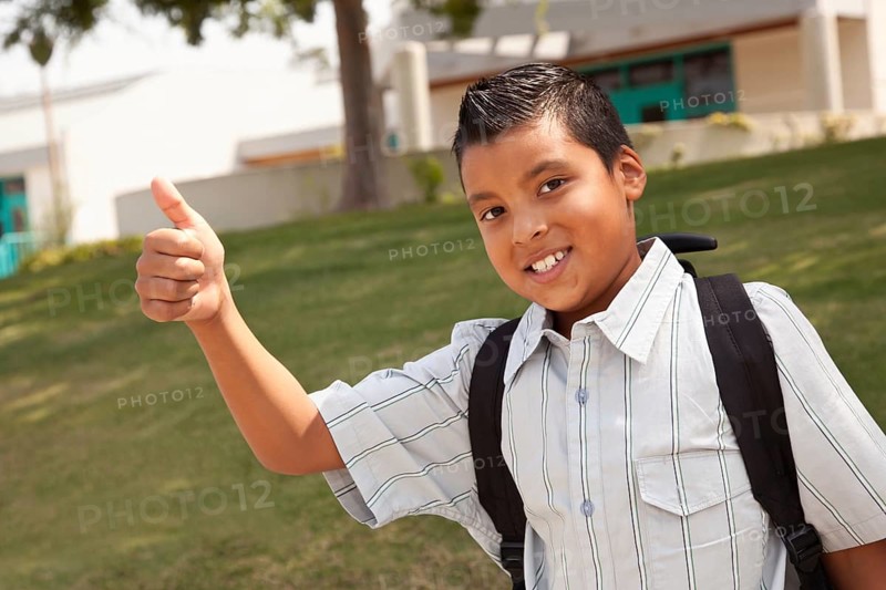 Happy young hispanic school boy with thumbs up one morning
