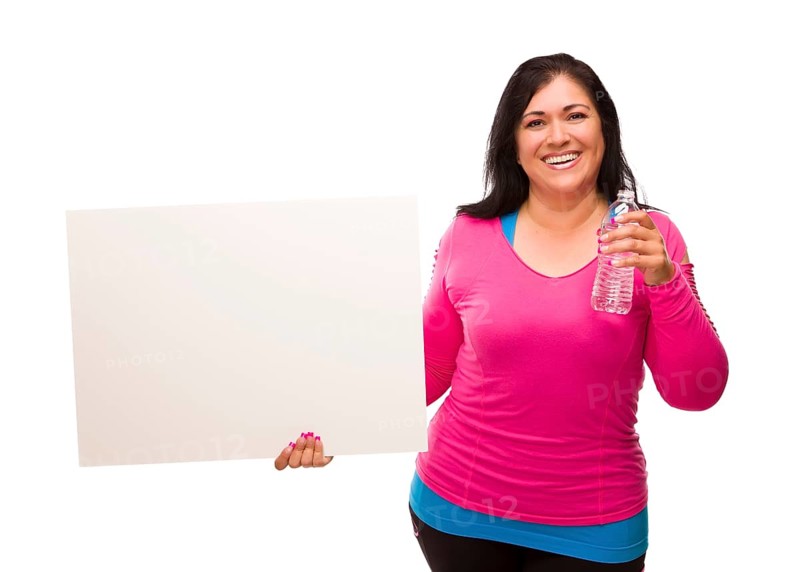 Attractive middle aged hispanic woman in workout clothes with water bottle and blank white sign against a white background