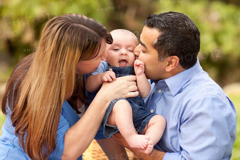 Happy mixed-race parents playing with their giggling son