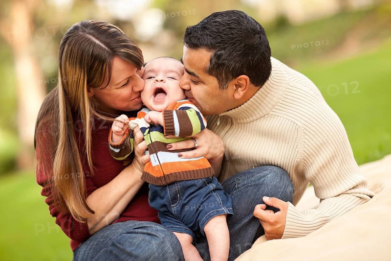 Happy mixed-race parents playing with their giggling son