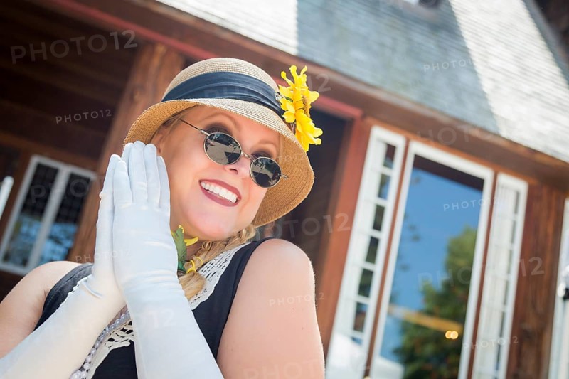 Attractive young woman in twenties outfit near antique house