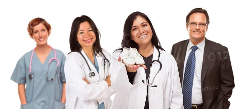 Attractive hispanic female doctor or nurse holding out baby shoes and support staff behind isolated on a white background