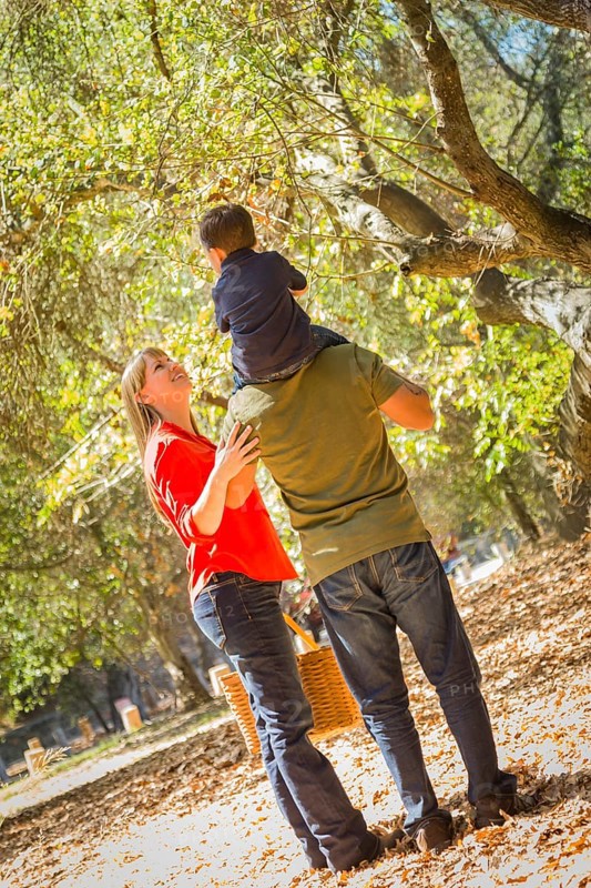 Happy mixed-race family with picnic basket enjoy a walk in the park