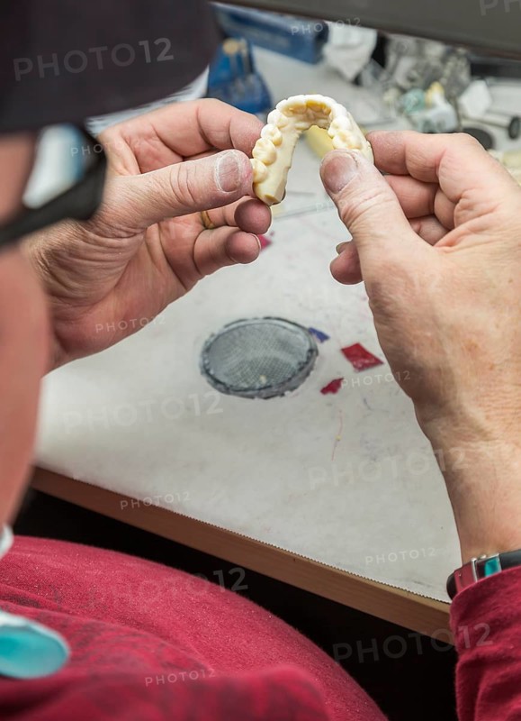 Male dental technician working on A 3D printed mold for tooth implants in the lab